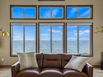 Experience coastal elegance in this room featuring a perfect blend of interior decor, soft textures, warm color tones, and comfortable furnishings, all while enjoying the magnificent ocean views.