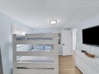 Queen bunk beds in guest room with tv