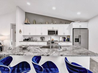Head on over to the fully equipped kitchen area, enjoy snacks on the beautiful kitchen island with the three stylish blue stools. With so much worktop space, cooking in this kitchen is a true delight.