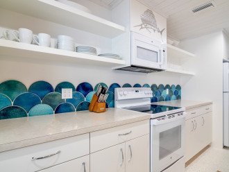 Watercolored handmade, hand glazed terra cotta tiles are the focal point of this fully stocked cottage kitchen.