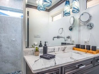 This beachy bathroom is complete with shower supplies, hair dryer, wall mirror