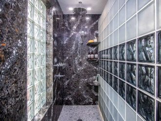 An extra large shower complete with shower supplies, body sprays, and rain head