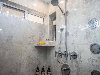 The large walk-in shower has body sprays and a ceiling rain head