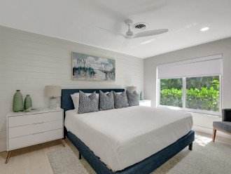 Step into Bedroom 2, featuring a king-sized bed, two side tables, and a ceiling fan, now complemented by the added allure of a spacious window offering natural light.