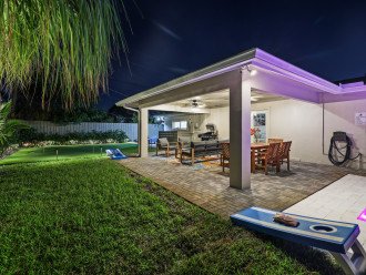 Nighttime bliss: Experience enchanting evenings on our well-lit covered patio, surrounded by entertainment options including corn hole, a sparkling pool, and a putting green, creating the perfect ambiance for memorable moments.