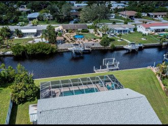 Aerial view of canal, boat lift, pool and back yard