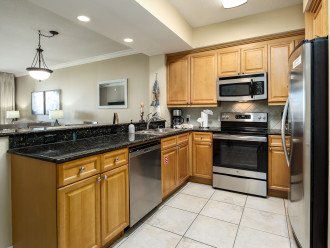 Galley Style Kitchen features Stone Counter tops & Stainless Steel Appliances