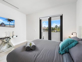 The third bedroom features a king size bed, smart TV, ensuite bathroom and balcony access with waterfront views.