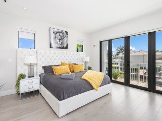 Primary bedroom featuring waterfront views and balcony access.