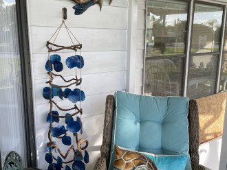 Reclining chairs with ottoman to snooze on the lanai. Shell Wind chimes subtle