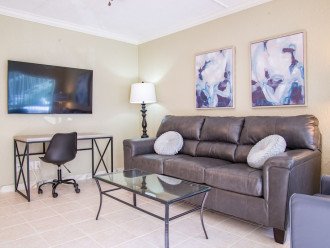 Enter the open space living room and relax on comfortable leather furniture including a recliner in front of the 55” smart TV.