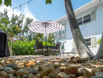 East side yard includes outdoor furniture, BBQ grill and lush landscaping. This is a shared space with the other guests staying at Paradise Shores.