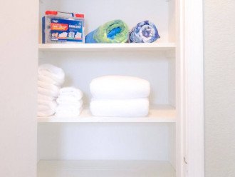 1st bedroom linen closet includes beach towels, white bath towels and a first aid kit.