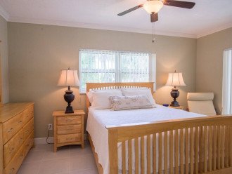 The fully furnished en-suite bedroom #1 includes a queen size bed wrapped in plush linens, plenty of storage for personal belongings, a sitting area, ceiling fan and private access to the Florida Room enclosed patio.