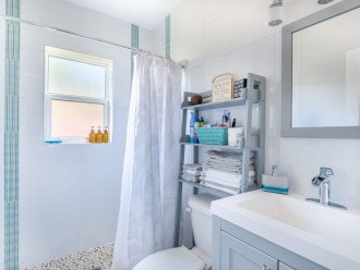 Full shower, vanity with bathroom amenities.