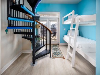 Twin Bunk beds off of the stair well and a spiral staircase leading to the third floor