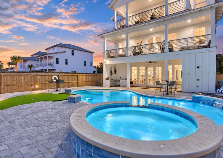 Resort-style backyard featuring a private pool, spa, putting green, and multiple outdoor lounging areas.