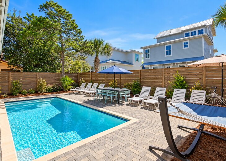 The private pool area features lounges, poolside tables and chairs, a hammock, and a grill.