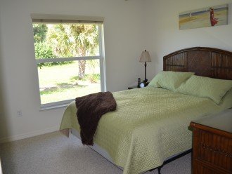 Second bedroom with a queen bed and large window