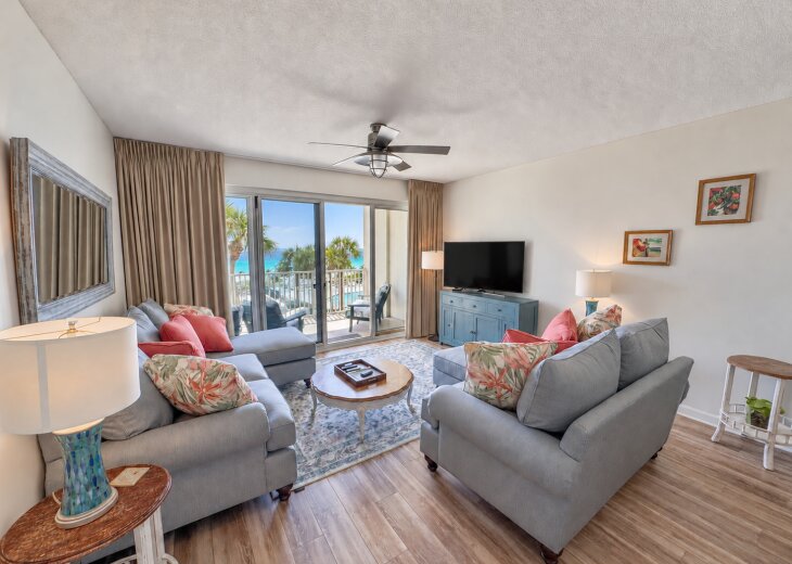 Living room with updated seating, a TV, and direct balcony access with Gulf views.