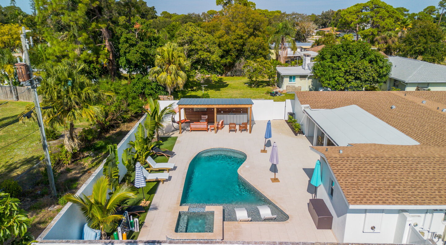 Your own private tropical paradise awaits with a stunning pool and spa surrounded by lush palms and spacious outdoor lounging areas perfect for soaking up the Florida sunshine.