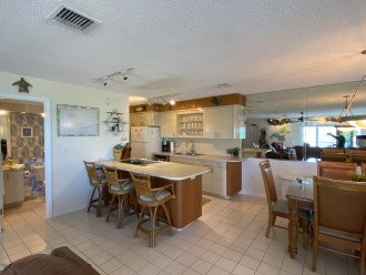 Open kitchen with ample counter space and seating for three.