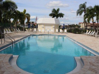 Heated pool with graduated steps and marina view. Palm trees add shade.