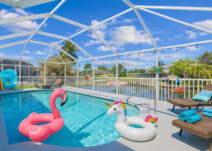Screened waterfront pool with loungers, canal views, and playful floats