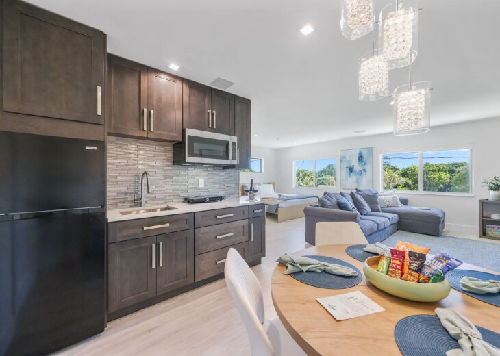 Bright, open Studio Palms pairs a modern kitchenette, dining space and comfortable lounge with large windows and a dedicated sleeping area—an inviting Delray Beach studio for couples, solo travelers or extended stays near downtown.