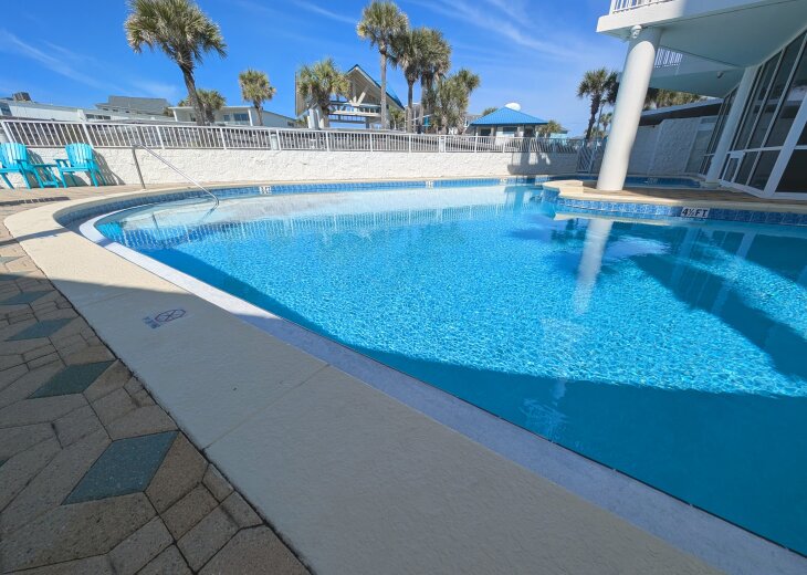 Sparkling resort pool with palms, loungers, and easy step-in entry