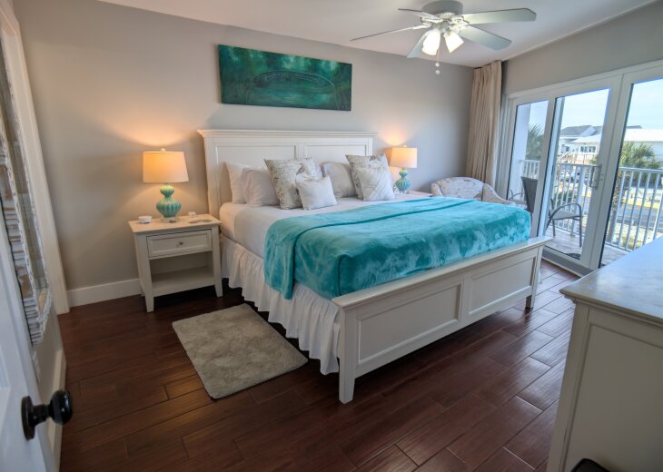 Bright coastal king suite with balcony and water-view breeze