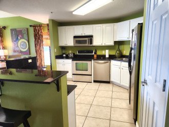 Modern kitchen with granite counters, stainless appliances & breakfast bar