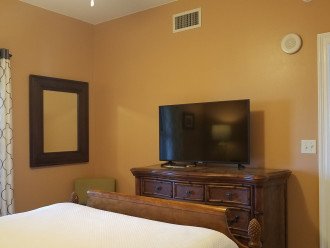 Guest bedroom has queen size bed, flat screen TV & large dresser for storage