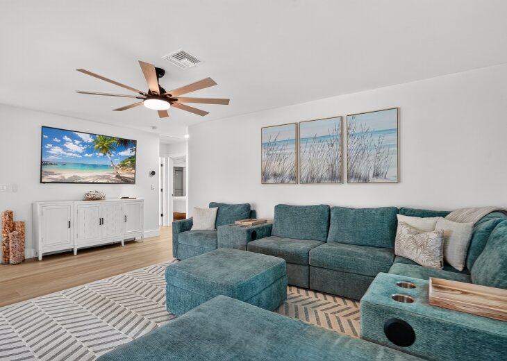 Relax in the bright, spacious living room with an oversized chaise sectional and a 75-inch smart TV.