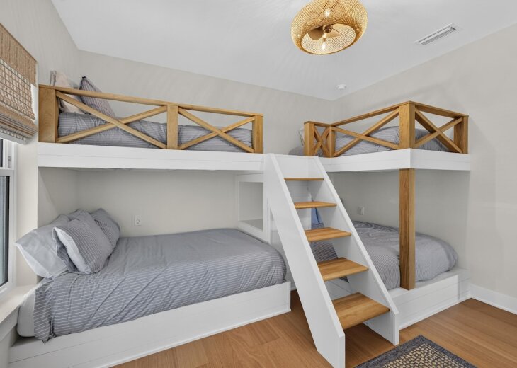 These custom-built bunk beds are in easy reach with natural wood guardrails and an angled ladder.