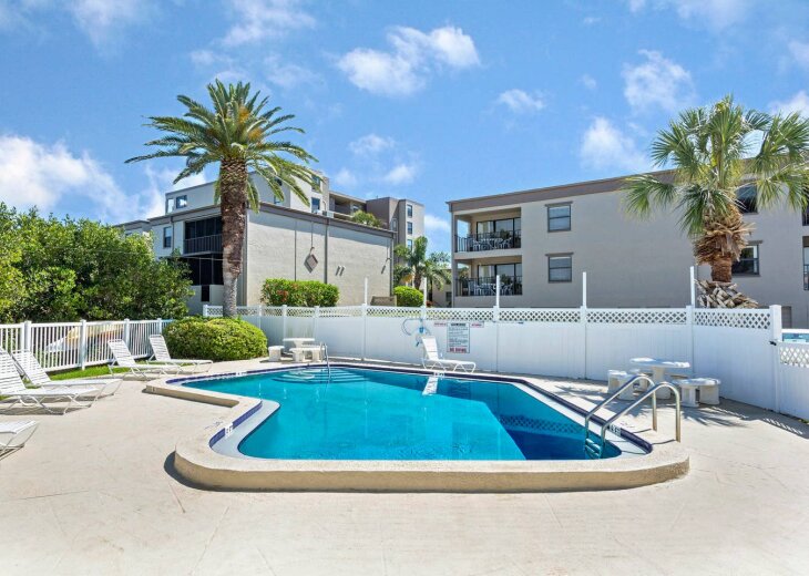 Community pool surrounded by palms
