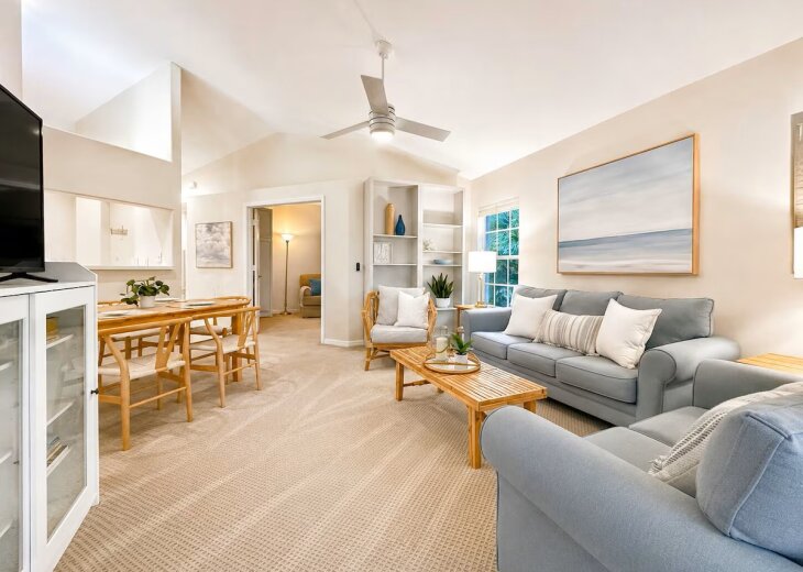 Living room with TV, built-in bookshelves & vaulted ceilings.