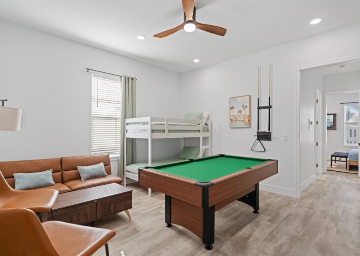 A second living space located upstairs with a pool table and large smart TV (twin on top and bottom)