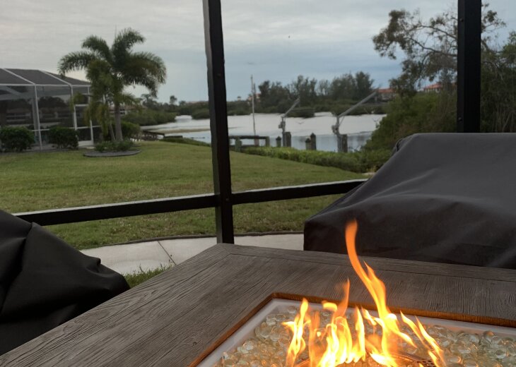 Screened lanai with gas fire table and 4 chairs with water voew