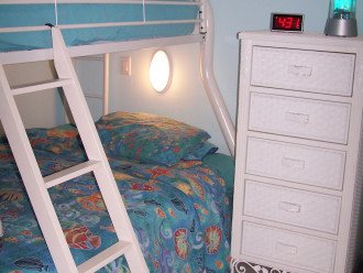 Second bedroom contains bunks beds featuring a double and a twin bed on top.
