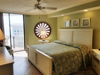 Master Bedroom King Sized Bed Ceiling Fan & a Nautical Wheel on the Window