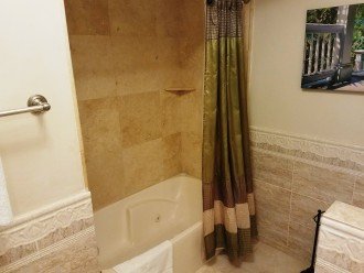 Shower/combo master bathroom with tile walls