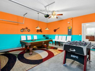 Game room with full size pool table, bar table and chair, foosball table.