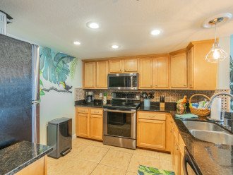 Updated kitchen with black stainless appliances. Hand painted wall mural.