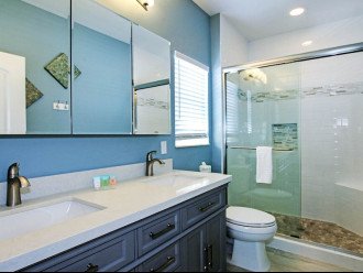 Master bathroom with walk-in shower and dural sinks.