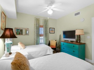 2nd guest bedroom has a dresser for storage and flat screen TV for private viewing