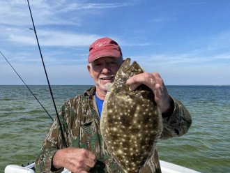 Doc holding my flounder I caught. (Well he is a charter captain.)