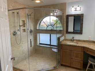 Master bath has two separate sprays in large enclosed glass shower.