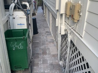 Walkway to back patio and trash/recycle receptacles