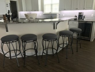 Kitchen seating area with five stools.